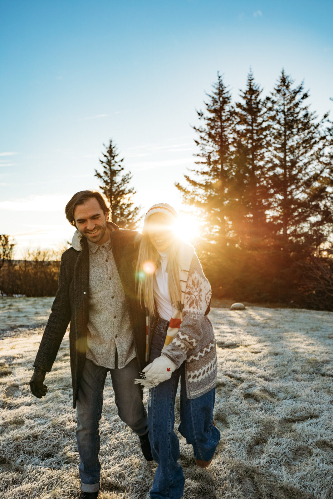 Couple walking in Iceland at sunset with sunlight through the trees
