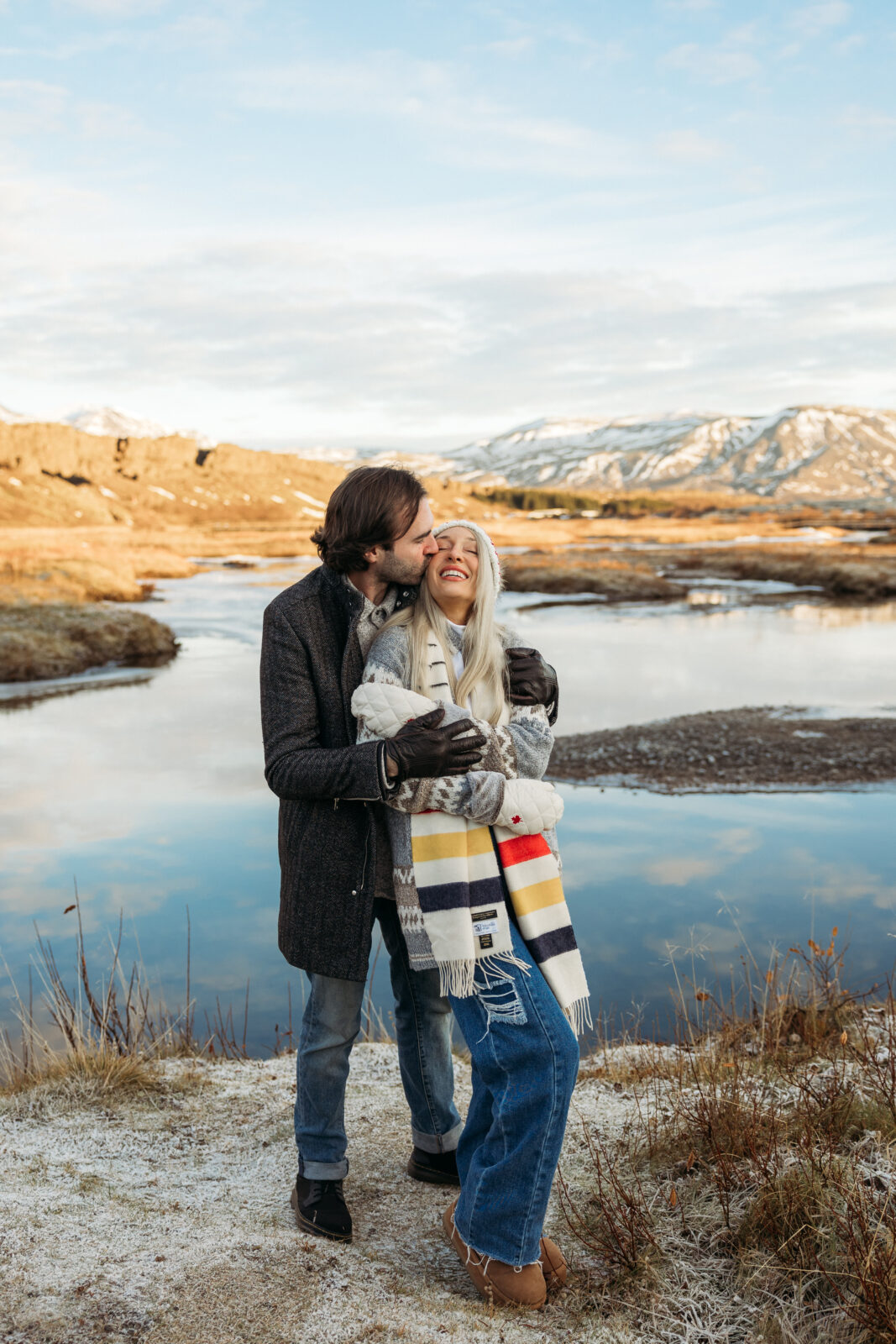Jess and Aaron hugging during an Iceland couples session by the water