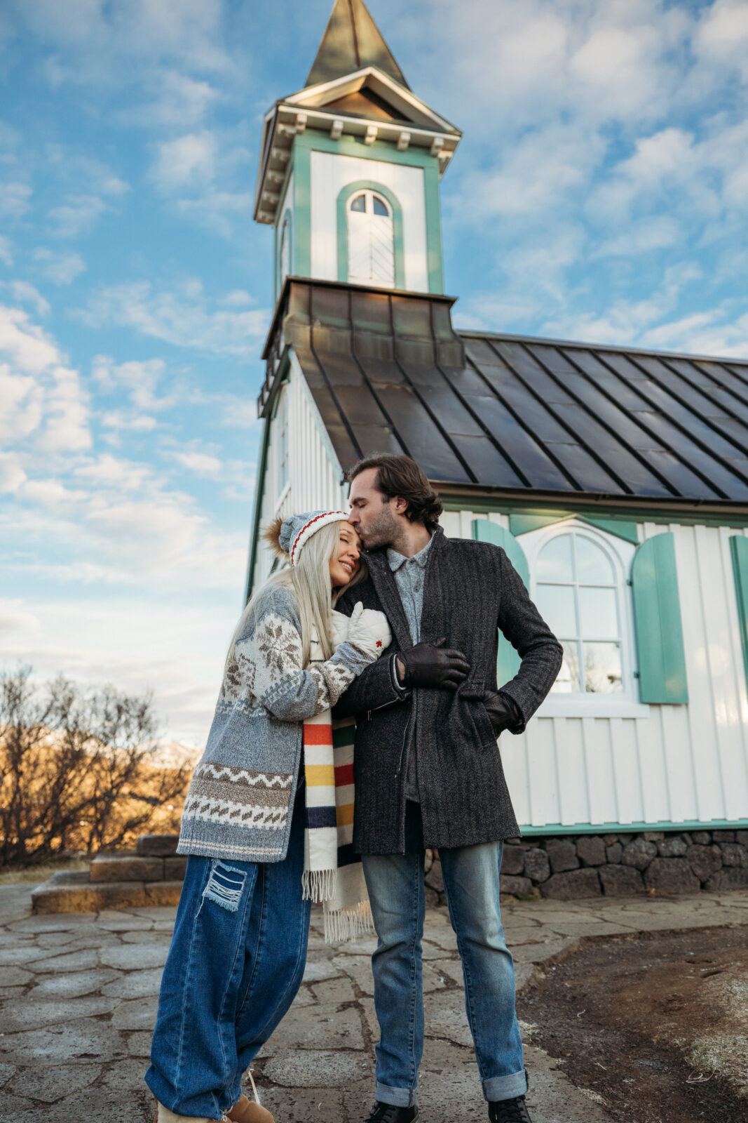 Couple kissing near a small church during an Iceland destination couples session
