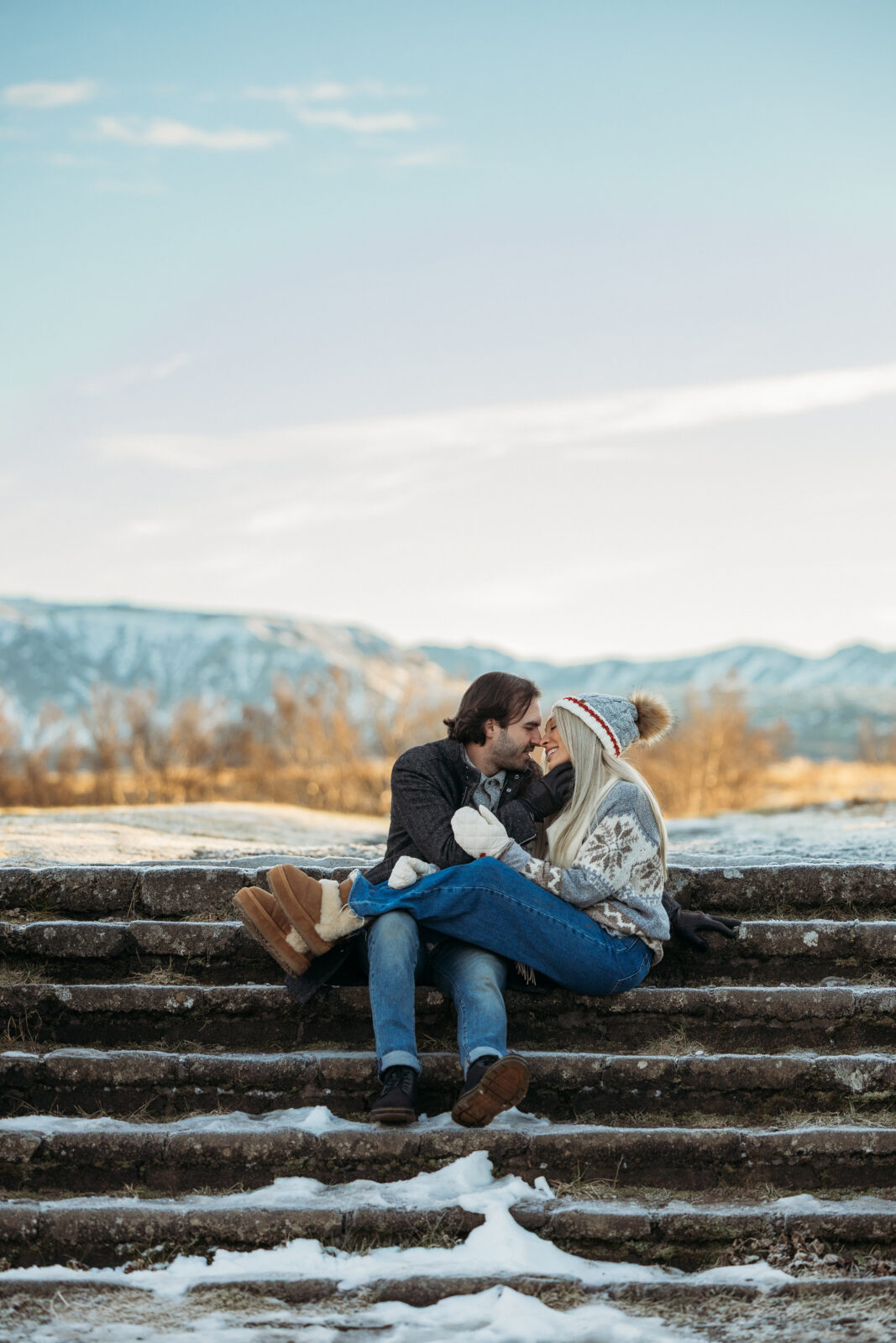 Couple kissing on stone steps during a winter couples session in Icela